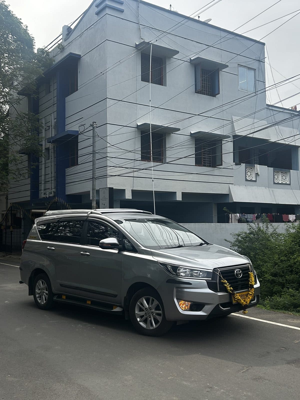 Toyota Innova Crysta taxi parked outside a Chennai residence — Magizhunthu Mobility